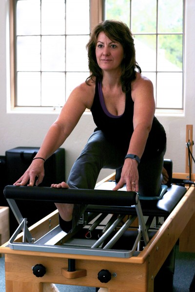 The author Kim Padilla working out on a Pilates Reformer at White Mountain Pilates Studio in Mt. Shasta. Photo by Audrianna Thompson. 