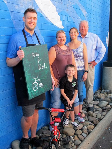 Left to Right: Casey Ripley from Starbucks, Jessie Cork and Bristol Nash from Youth & Family Programs, Ted Blankenheim, and young Jaxsyn Tyson. All enjoy community activism and sharing their enthusiasm for children receiving holiday bikes.