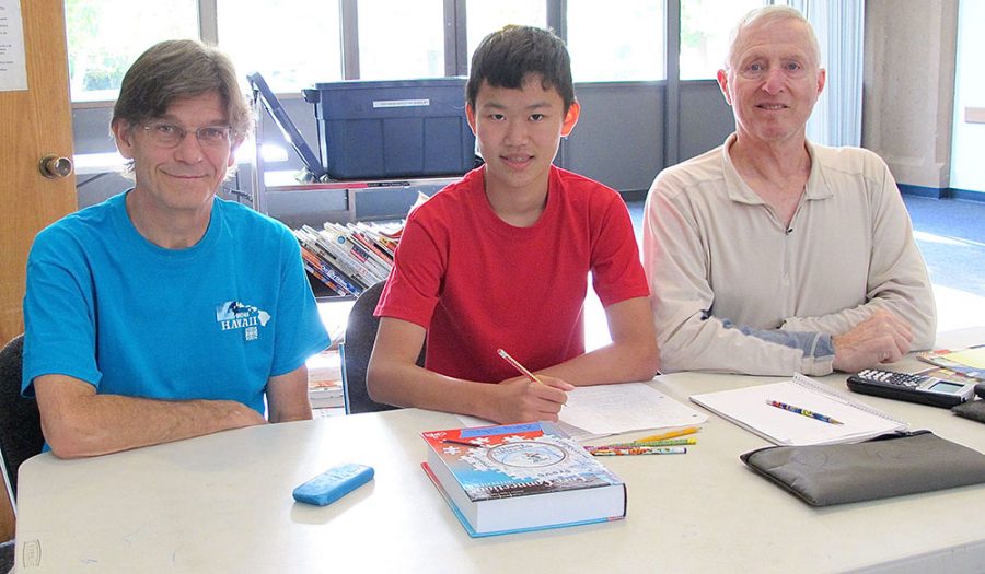 Jonathan Jordan and Mike St. John, both former educators, work with student Xing Shen, a Chico High School student, during the Chico Branch Library's Homework Help drop-in program.