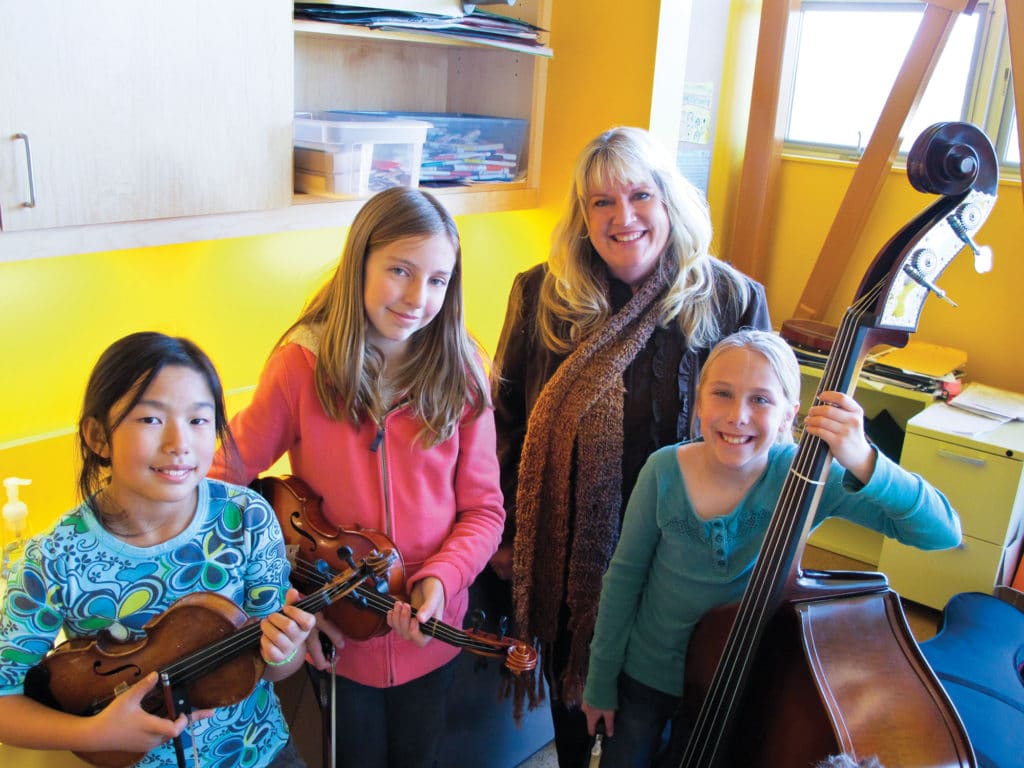 Sheri Eby poses with students and shares the benefits of music - north state parent
