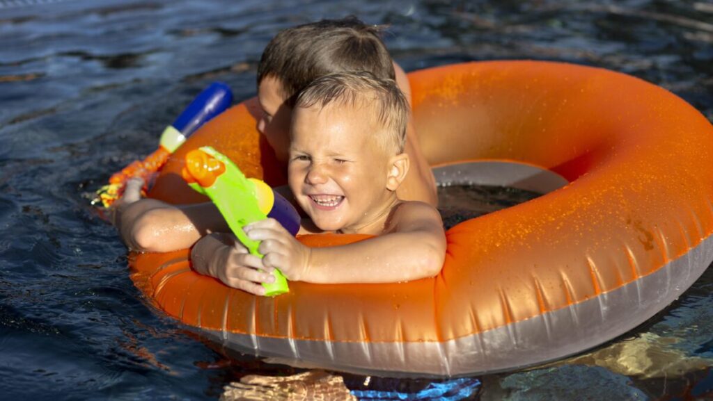 boys-having-fun-swimming-pool-with-pool-float-water-gun