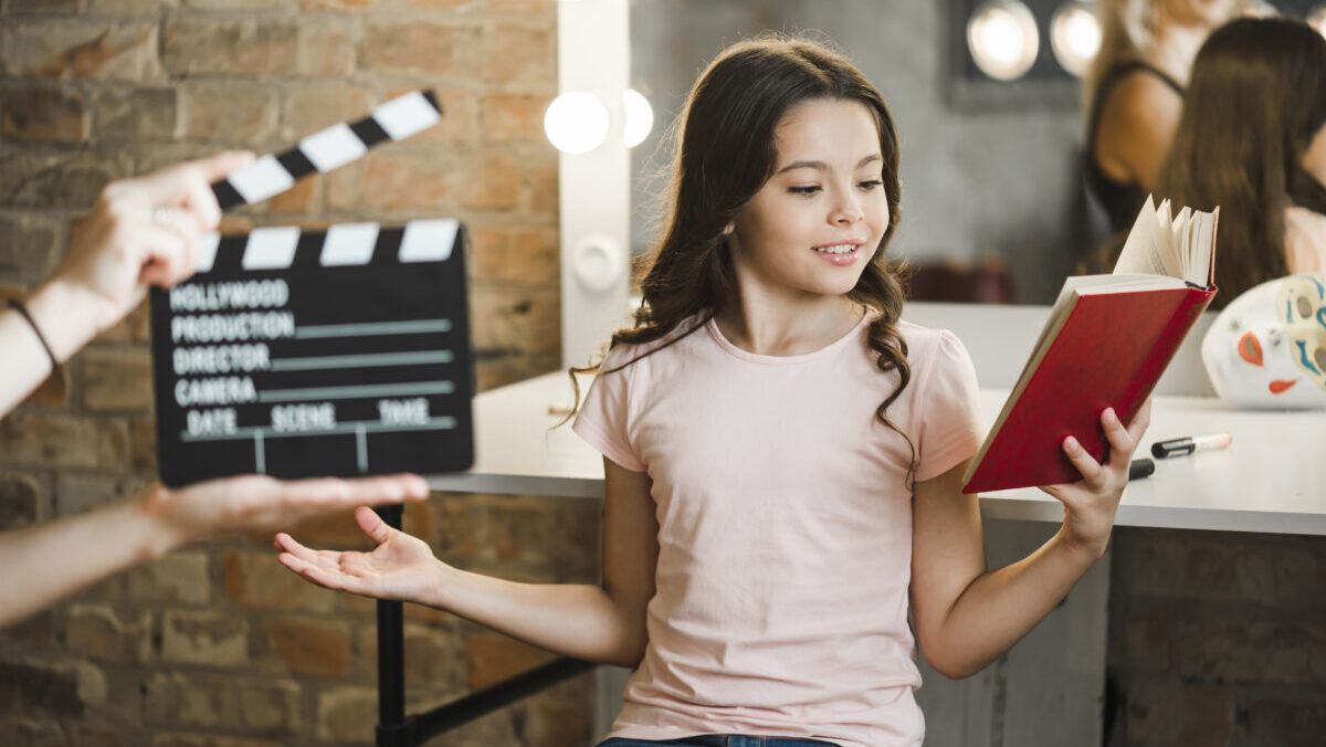 person-holding-clapperboard-front-girl-rehearsing-backstage
