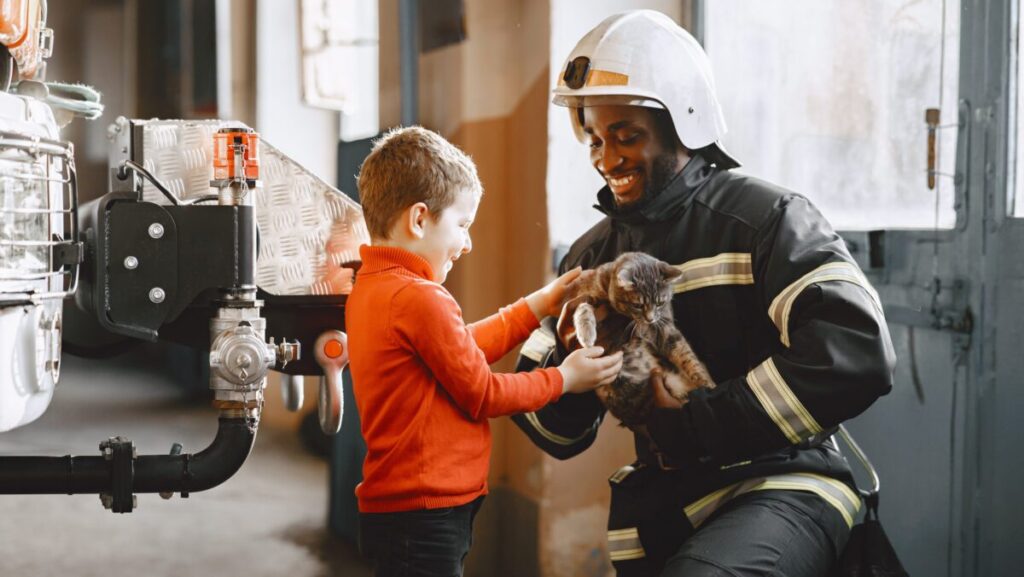 Arfican fireman in a uniform. Man prepare to work. Guy with child.