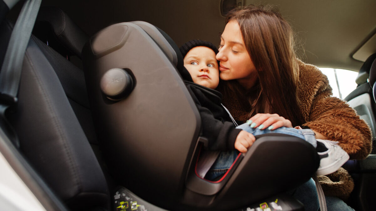 Young mother and child in car. Baby seat on chair. Safety drivin
