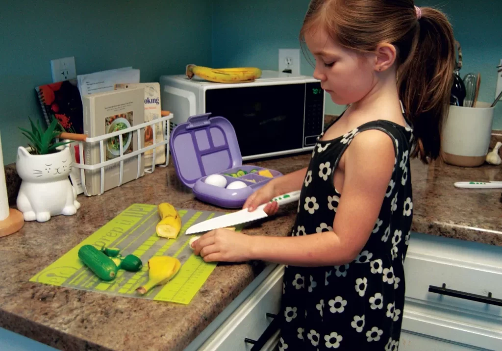 Six-year-old Aria from Red Bluff is proud to help prepare her school lunch. When children participate in making their school lunches, the food is much more likely to come home in their tummies than in their lunch bags. Photo by Kimberly Parodi.