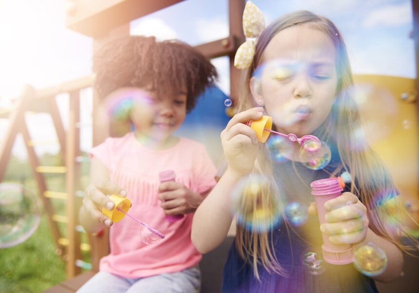 Two cute girls blowing the soap bubbles