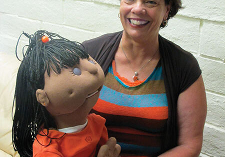 Kat with a child-sized puppet from RFENC's diverse-ability awareness & anti-bullying puppet presentations, available to schools and groups for children ages preschool-3rd grade.  