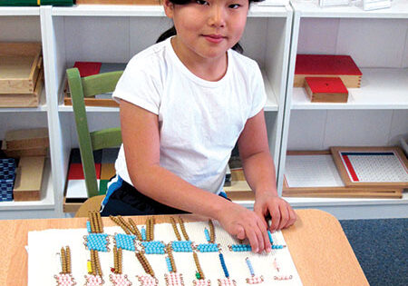 Mika enjoys working with Montessori Multiplication Beads at 
Middle Creek Montessori in W. Redding. Photo: Pamela Newman
